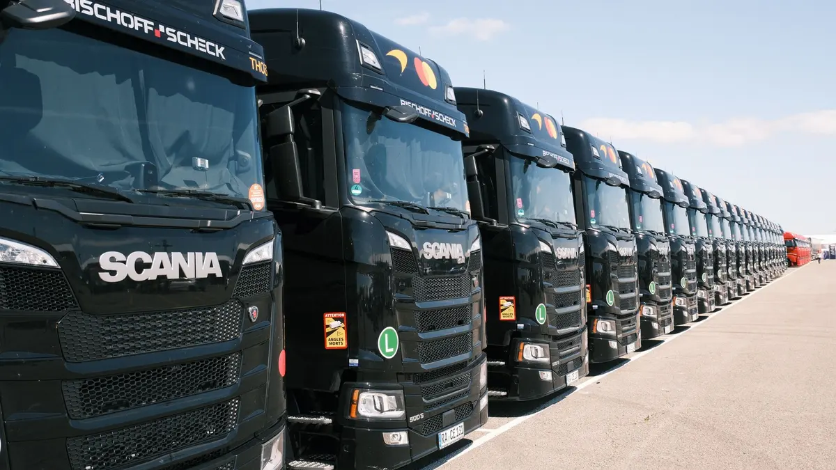 Frota de caminhões pretos enfileirados em pátio